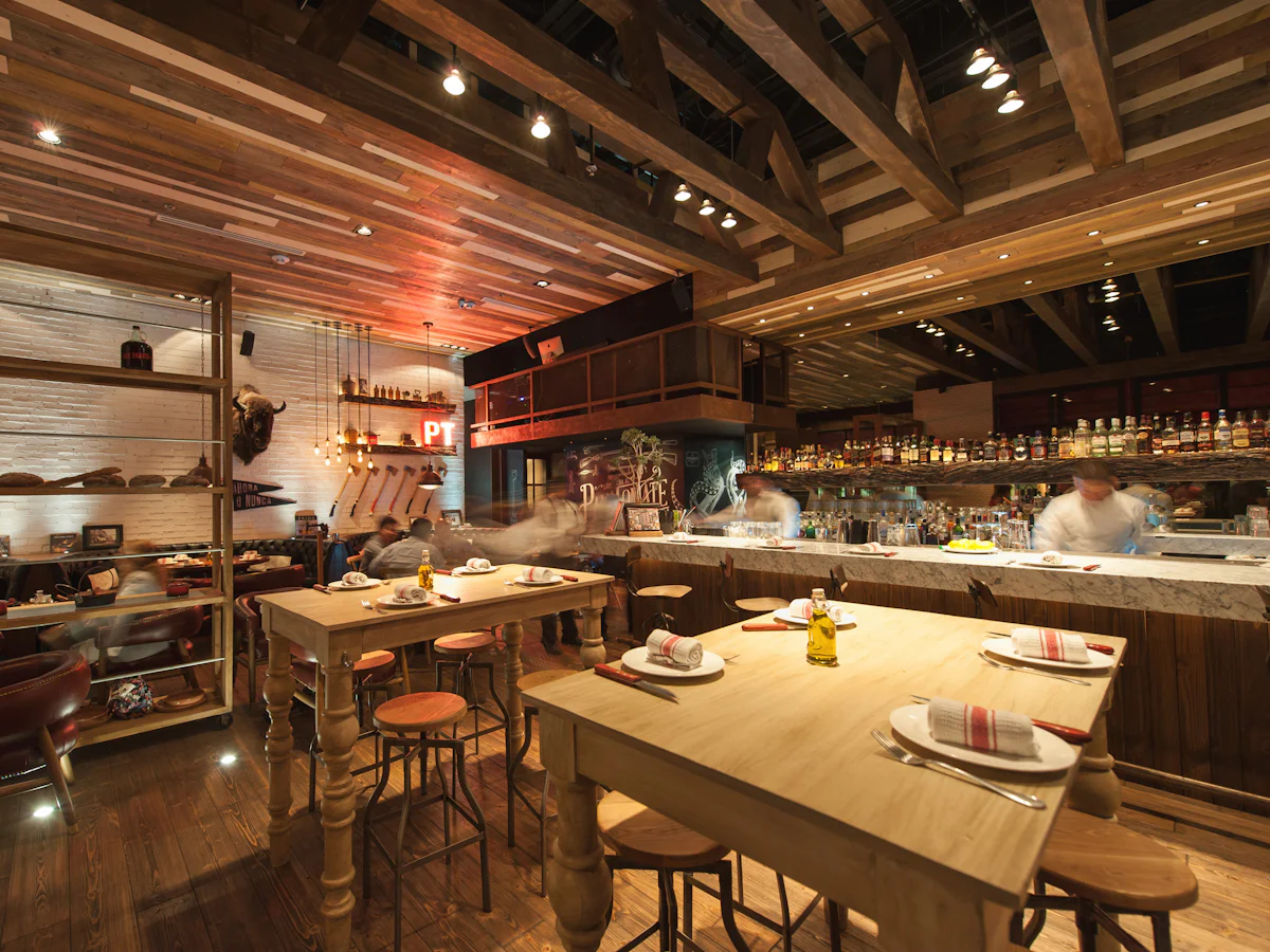 Unutrašnjost bistroa s drvenim stolovima i šankom