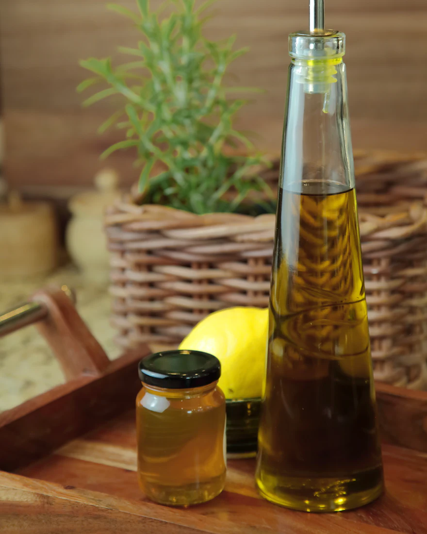 Maslinovo ulje, med, limun i ružmarin na drvenom pladnju